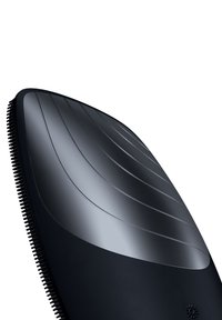 Svart groomingborste med en böjd design; har släta kanter och fina borst längs kanten för effektiv pälsvård.