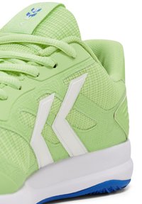 Jasnozielony but sportowy wykonany z siateczki i materiałów syntetycznych, z białymi akcentami, teksturowaną powierzchnią i niebieską podeszwą.