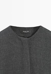 Tessuto grigio con texture, scollatura rotonda e pattina anteriore; presenta un'etichetta con la scritta "Massimo Dutti."