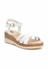 Sandalinas blancas con tiras, que presentan un upper texturizado, plantilla de corcho y una suela de plataforma con acentos de aspecto madera. Correa ajustable en el tobillo con hebilla.