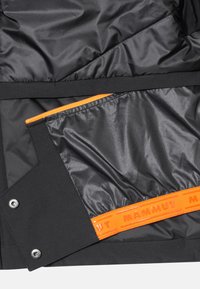 Black jacket interior featuring a smooth orange zipper pocket and a contrasting orange brand label. Made of durable, water-resistant material.