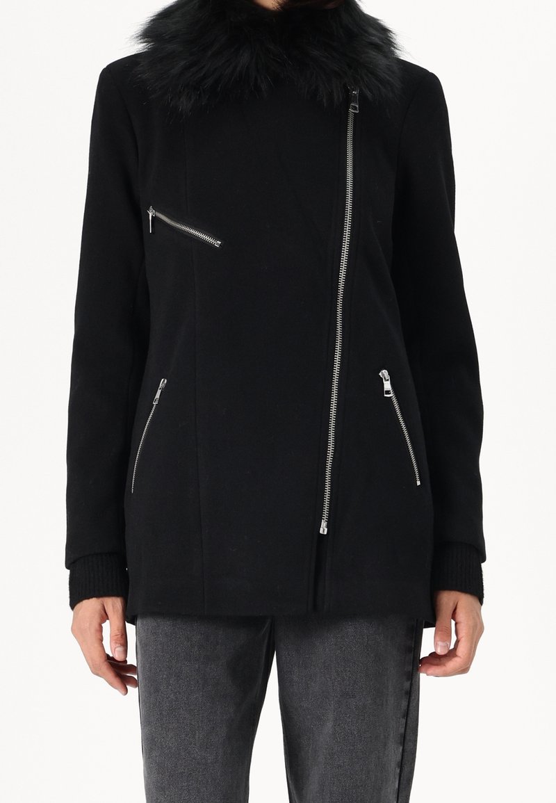 Černá bunda s límcem z umělé kožešiny, předními zipy a bočními kapsami. Má strukturovaný střih a žebrované manžety. Hladká textura.