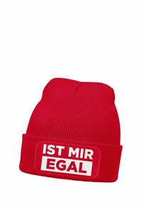 Red knit beanie featuring a turned-up cuff with a rectangular patch displaying the text "IST MIR EGAL" in bold white letters.