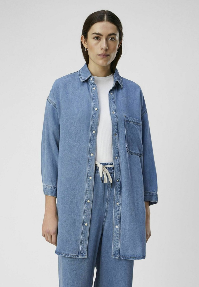 Game Pawns All Over Faces Print Button-Up Light Denim Blouse Light Blue
