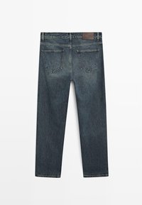 Jeans in denim blu scuro con taglio dritto classico, dotati di due tasche posteriori e una etichetta in pelle sulla vita.