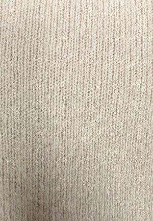 Jasnobeżowa dzianina o drobnej, pionowej fakturze prążkowania. Materiał wydaje się miękki, z subtelnymi różnicami w głębokości i lekko puszystą powierzchnią.