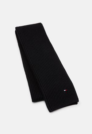 Czarny prążkowany szalik wykonany z dzianiny, z małym logo w kolorach czerwonym, białym i niebieskim. Długi, prostokątny kształt z teksturowaną powierzchnią.