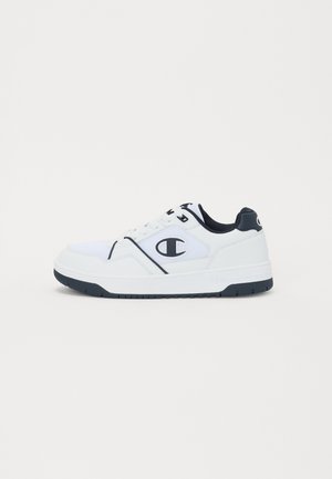 Fehér sportcipők sötétkék kiegészítővel, textilekből és szintetikus anyagból készült felsőrész, kerek orr, texturált talp, valamint logó az oldalon és a sarokon.