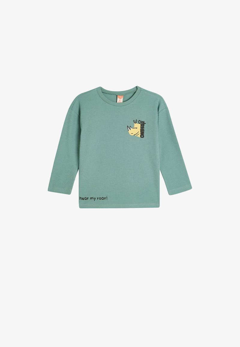 Langärmliges grünes Baumwollhemd mit einem gelben Nashorn-Graphic und dem Text "hear my roar!" in Schwarz gedruckt. Strukturiert.