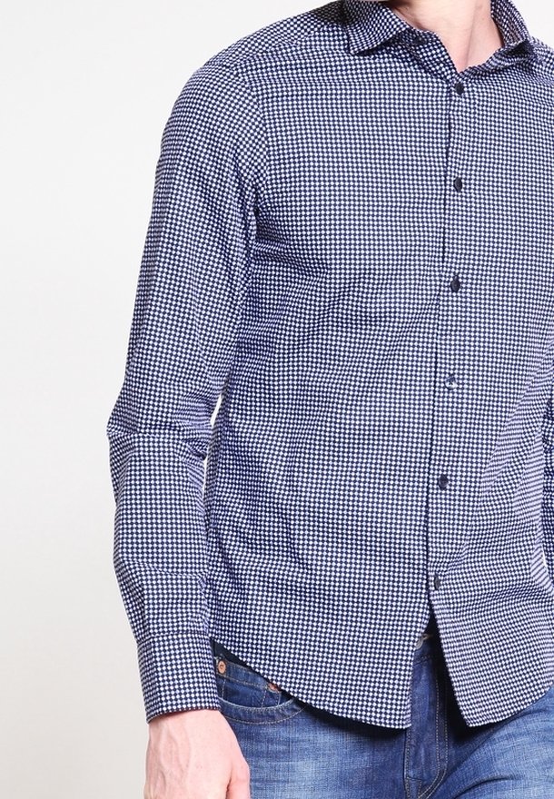 Blå och vit rutig skjorta med långa ärmar, knäppkrage och normal passform. Har en subtilt strukturerad tygkvalitet och knäppning fram.