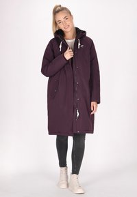 Bordo parka plašč z kapuco, zapiranjem na zadrgo in gumbih, stranskimi žepi in vrvico. Gladka textura z toplo, izolirano zasnovo.