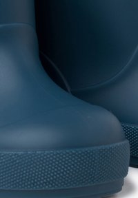 Botas de lluvia de goma de color azul oscuro con un acabado suave, punta redonda y suela texturizada para un buen agarre. Diseño minimalista sin hardware o acentos visibles.
