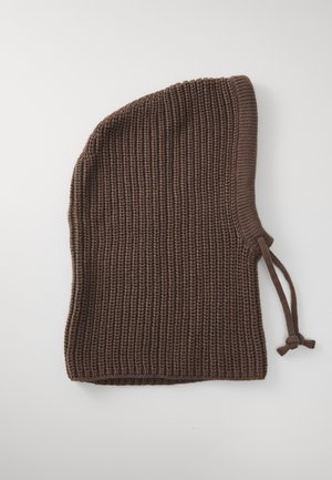 Brun strikket balaklava med ribbestrikket mønster og justerbare snorer på den ene siden, liggende flatt på en hvit overflate.