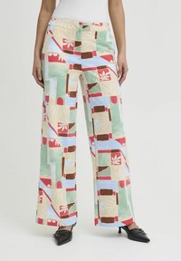 Pantalons à jambes larges avec un motif géométrique coloré en vert, rouge, bleu et beige. Comprend des poches latérales et un tissu lisse et léger.