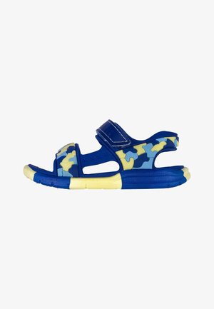 Blaue Sandalen mit einem Puzzle-Muster in Gelb- und Blautönen. Mit verstellbaren Riemen und einer strukturierten Gummisohle.