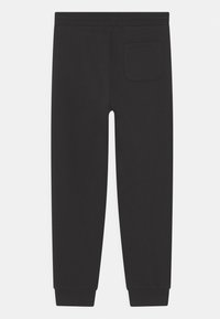 Svarta sweatpants har en slim fit, elastisk midja och ribbade muddar. En liten bakficka ger funktionalitet till designen.