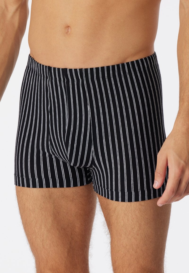 Boxer shorts a strisce nere realizzati in tessuto morbido, con sottili strisce bianche verticali, un design aderente e una cintura elastica.