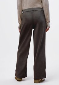 Široké kalhoty tmavě šedé barvy z měkké látky, s hladkým pasem a rovný střihem. Volný střih, minimální detaily.