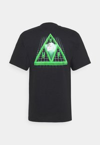 Svart t-shirt med en grön grafisk design av en triangel med ett ansikte inuti och ett rutmönster, tydligt placerad på ryggen.