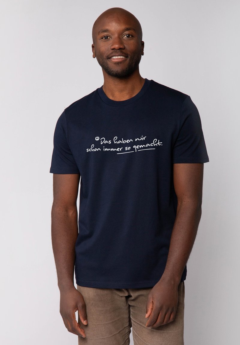 Marineblauwe katoenen t-shirt met op de voorkant handgeschreven witte tekst, een ronde hals en korte mouwen. Glad textuur.