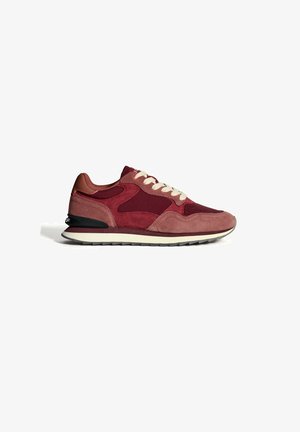 Zapatillas de ante burdeos y rosa polvo para hombre con cordones blancos y suela con acentos en negro, perfil lateral sobre fondo blanco.