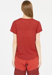 Rød t-shirt med kort ærme, vandret striber, blød tekstur og en rund kant, parret med matchende røde shorts.