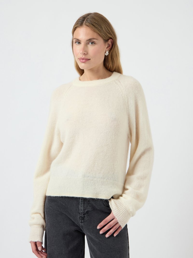 Maglione color crema realizzato in materiale morbido, con una vestibilità comoda, orlo e polsini a costine, maniche lunghe e scollatura tonda.