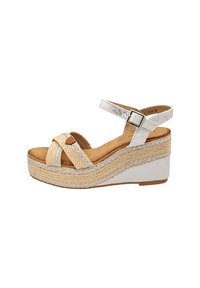 Sandale à semelle compensée avec une base en jute tressé, tige en synthétique argentée, bride de cheville ajustable et semelle intérieure beige avec un design à croisement à l'avant.