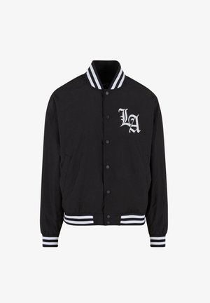Musta bomber-jakk, millel on valge LA logo, triibuline krae ja varrukad, nööbiploki sulgemine, kaks küljetaskut ja sile kangastekstuuri.