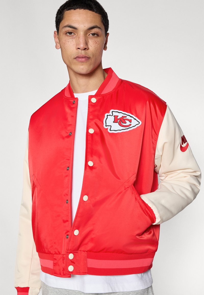 Rote Satin-Collegejacke mit beigen Ärmeln, ausgestattet mit einem Logoaufnäher auf der Brust, gerippten Bündchen und Druckknopfverschluss.