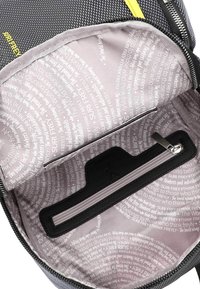 Grå och svart ryggsäckens insida med en zippered ficka, som har en mjuk, mönstrad foder i ljusgrått med repetitiva textelement.