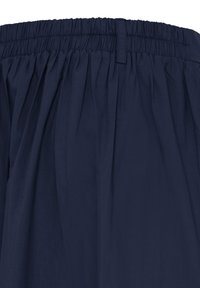 Pantaloni blu navy con fascia elastica in vita e passanti per cintura, caratterizzati da morbide pieghe sotto la vita.