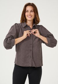 Hnědá, texturovaná košile na knoflíky s límečkem a nabíranými rukávy. Obsahuje rovný střih a knoflíky po celé délce.