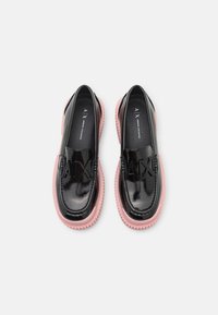 Mocassins en cuir verni noir avec semelles en caoutchouc rose et logo AX en relief sur le dessus vus de dessus sur un fond blanc.