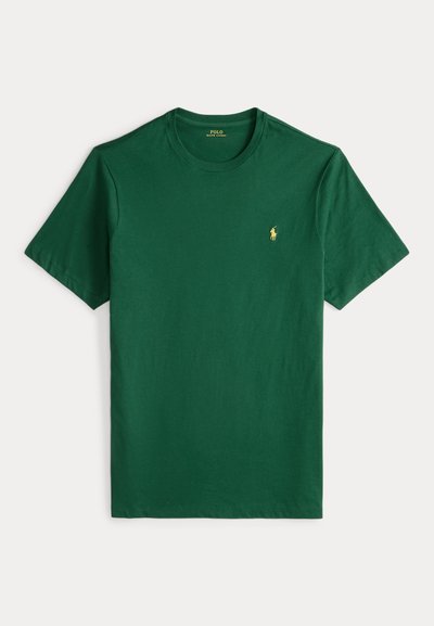 Πράσινο βαμβακερό T-shirt με στρογγυλή λαιμόκοψη, κοντά μανίκια και μικρό κίτρινο λογότυπο πόλο στο στήθος. Λείο ύφασμα και casual σχεδιασμός.