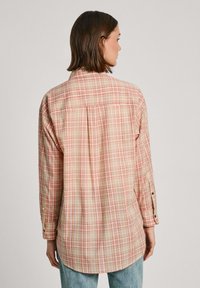 Gecheckt overhemd met lange mouwen in beige, roze en oranje. Bevat een achterste schouderstuk, knopenmanchetten en een ronde zoom. Katoenmengsel stof.