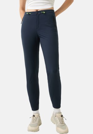 Granatowe spodnie Outdoor o slim fit, wykonane z lekkiego materiału, z zamykanymi na zamek kieszeniami i kontrastowymi neonowymi sznurkami w pasie.