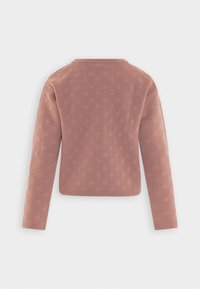 Long-sleeve, textured pink jacket with a dotted pattern, featuring a round neckline and a straight hem, suitable for casual wear.