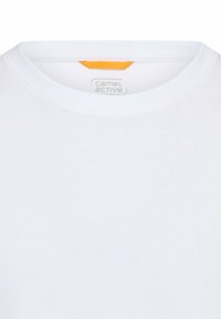 Biała koszulka z krótkim rękawem i okrągłym dekoltem, z małym pomarańczowym akcentem z tyłu oraz markową metką wewnątrz.