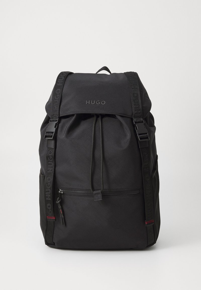 Black backpack featuring a drawstring closure, front zipper pocket, and branded straps. Made from durable material with a textured finish.