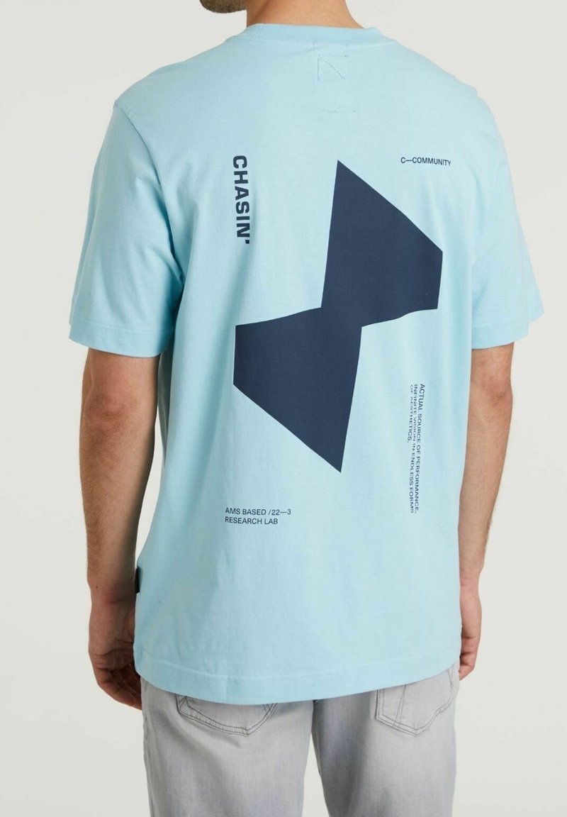 Helles blaues Baumwoll-T-Shirt mit großem marineblauen geometrischen Design auf der Rückseite, Texthighlights und kurzen Ärmeln mit Rundhalsausschnitt.