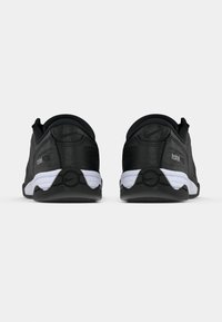 Μαύρα αθλητικά παπούτσια με υφή στην επάνω επιφάνεια, λευκή μεσαία σόλα και λαστιχένια εξωτερική σόλα. Διαθέτουν λογότυπο και διακριτικές λεπτομέρειες για καλύτερη πρόσφυση.