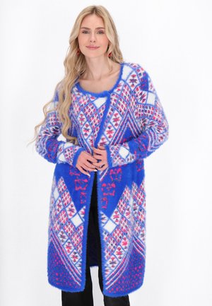 Cardigan lungo e morbido di colore blu con un motivo geometrico in rosa, bianco e rosso. Presenta un collo tondo e un design aperto frontale.