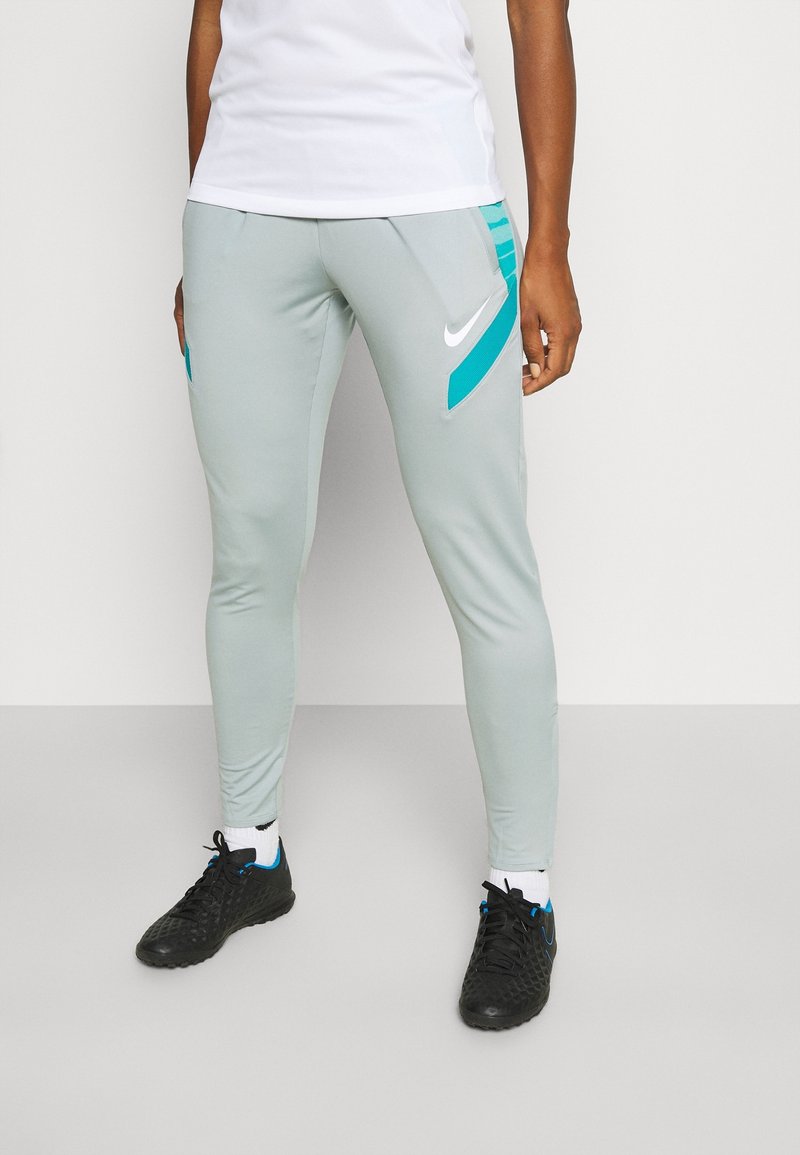Hellgraue Sportpants mit türkisfarbenen Akzenten, tailliertes Design und Nike-Logo. Verfügt über Reißverschlusstaschen und einen elastischen Bund für zusätzlichen Komfort.