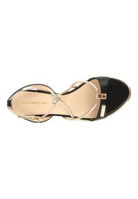 Sandalia de cuero negro con acentos metálicos dorados, con tiras entrelazadas y puntera redondeada. Textura suave, diseño elegante.