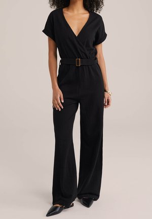 Czarny kombinezon z głębokim dekoltem w serek, krótkimi rękawami, paskiem w talii i szerokimi nogawkami, wykonany z teksturowanej tkaniny.