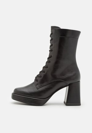 Black leather ankle boots with a rounded toe, lace-up front, and a chunky high heel. Smooth texture with minimalist design and no visible patterns.