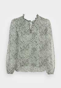 Ljusgrön, genomskinlig blus med rund halsringning, volangdetalj och mörka prickar. Har lång, ballongärmar och en nyckelhålsöppning framtill.