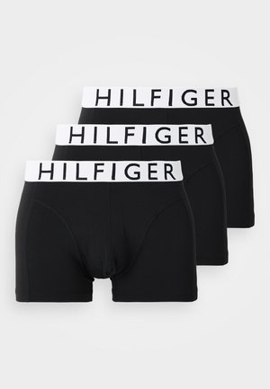 Tre par svarte boxershorts med hvit elastisk midjebånd som har "HILFIGER" merke. Glatt stoff, tettsittende design og kort benstil.