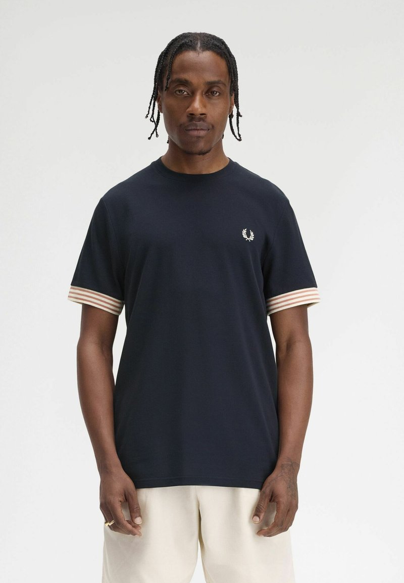 T-shirt blu navy in cotone, con accenti a righe sulle maniche e un piccolo logo sul petto. Tessuto morbido, scollo rotondo.